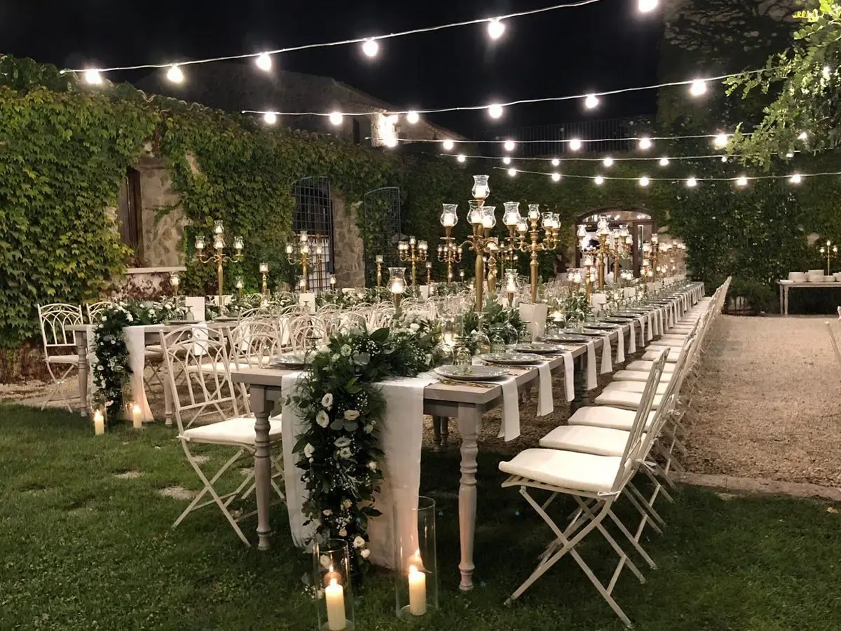 Outdoor wedding dinner with lights and candelabras at the Agrigento reception masseria